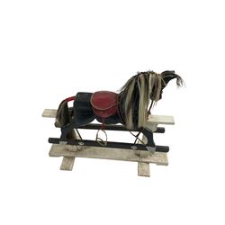 20th century black painted rocking horse on white painted trestle base, fitted with saddle and stirrups 