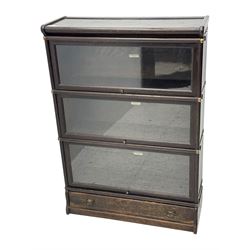 Globe Wernicke - early 20th century oak three-tier stacking library bookcase, three glazed sections enclosed by hinged and sliding doors, raised above a single lower drawer with metal drop handles