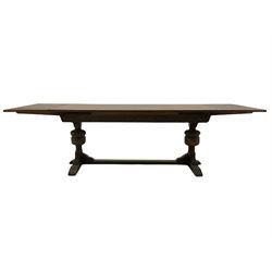 20th century oak drawer leaf extending dining table, two foliage carved baluster supports on sledge feet joined by floor stretcher 