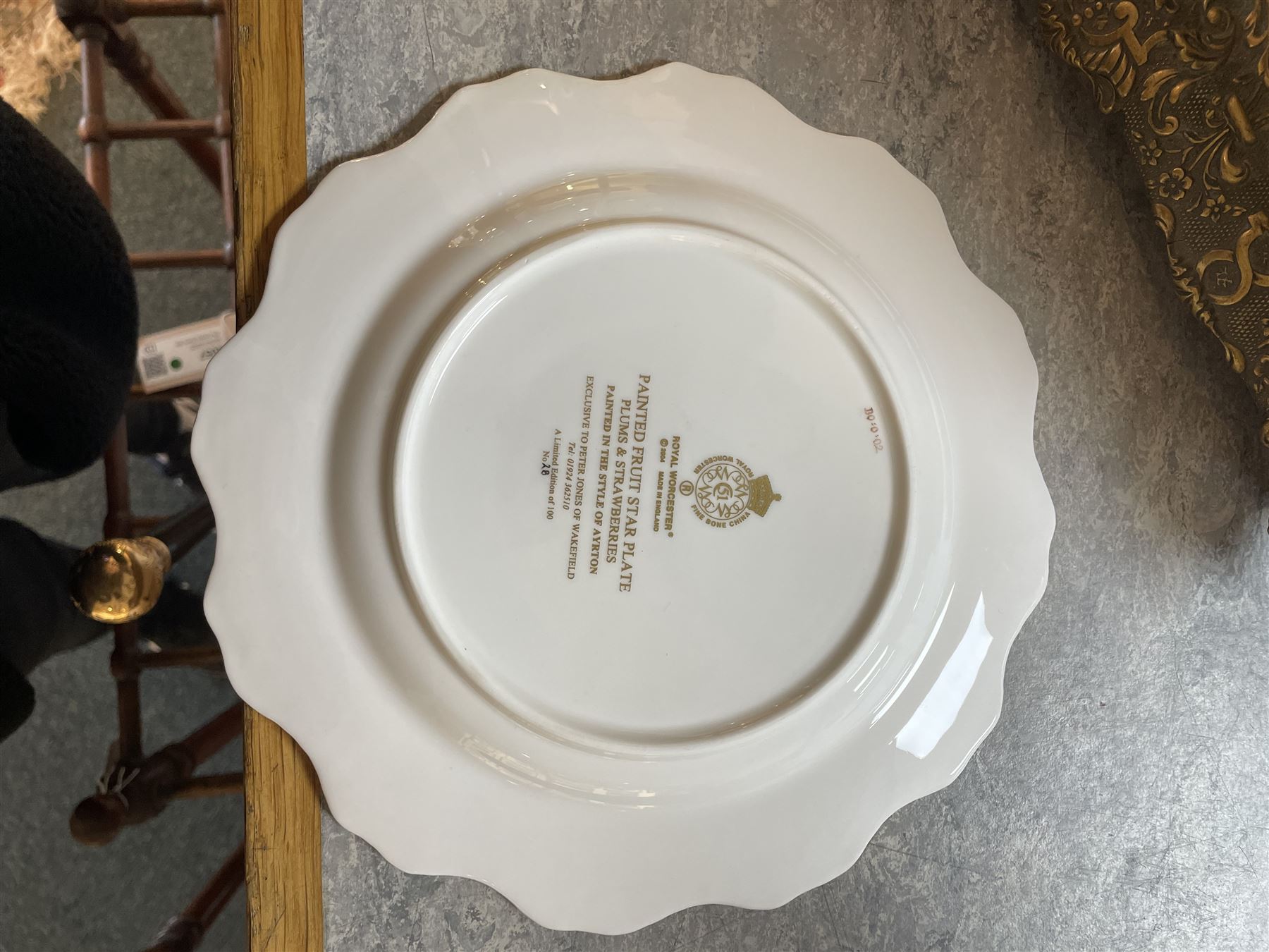 Late 20th century Royal Worcester star plate, of circular form with shaped with gilt shaped rim, hand painted by E Clark with still life of fruit upon mossy ground, signed E Clarke, with marks beneath including limited edition no 28/100, with makers fitted card box, D23cm
