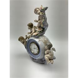 A Lladro mantel clock modelled as a globe with inset clock, surmounted by four putti and floral garlands, with blue printed mark and impressed 5973 beneath, H29cm.