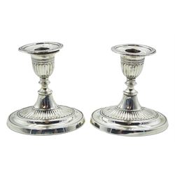 Pair of Edwardian silver Adam style style dressing table candlesticks, each with filled part fluted oval base leading to a short knopped stem, conforming part fluted capital and removable nozzle with husk border to rim, hallmarked Fordham & Faulkner, Sheffield 1906, H11cm
