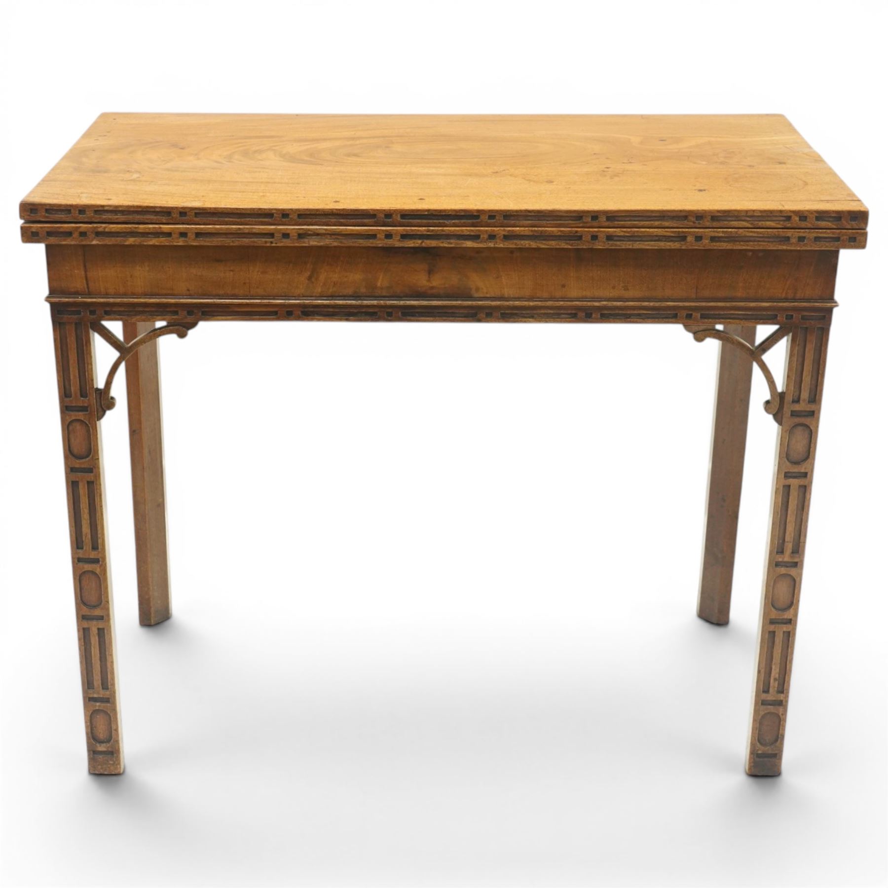 George III Chippendale design mahogany table, the rectangular hinged top with geometric carved edge, opening to reveal a baize-lined interior supported by twin concertina rear gateleg supports, over a banded frieze and pierced C-scroll spandrels, the inner chamfered square supports carved with geometric blind-fretwork detail