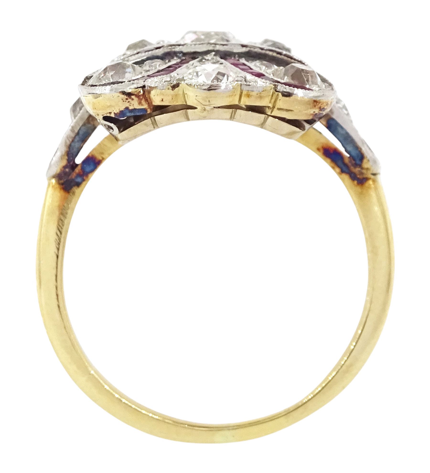 Early 20th century gold and platinum ruby and diamond panel ring, the principal old cut diamond of approx 0.30 carat, with old cut diamond surround and milgrain set calibre cut ruby ribbon motif, the tulip head shoulders set with a further diamond and ruby, total diamond weight approx 1.75 carat
