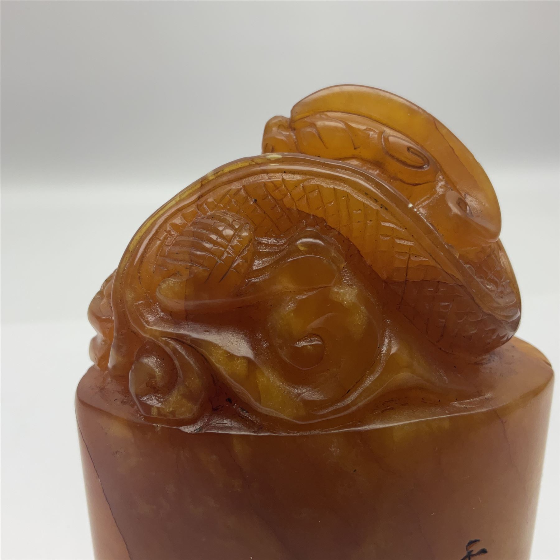 Chinese amber soapstone seal of oval form,  carved temple dog finial, inscription on the back and base, H12cm