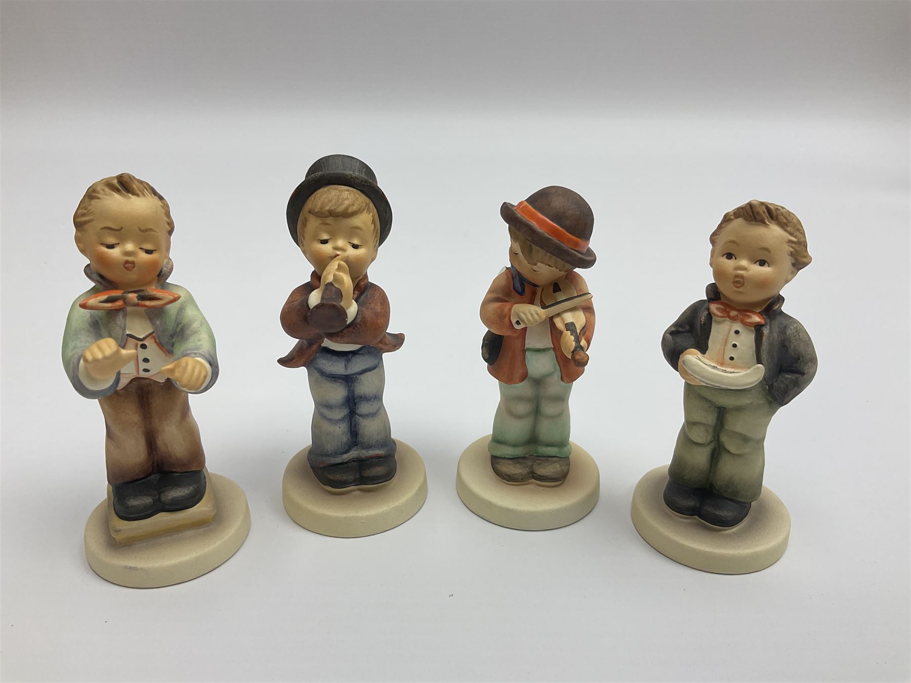 Thirty Hummel figures by Goebel, to include Saluting the Peacekeepers of Operation Joint Endeavor, on wooden plinth, Call to Glory, Celebrate with Song and Soldier Boy