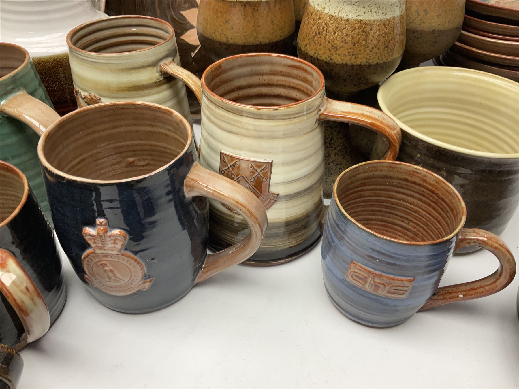 Wold studio pottery tankards, in various colours and relief decoration together with other studio items including vases, jugs and pots 