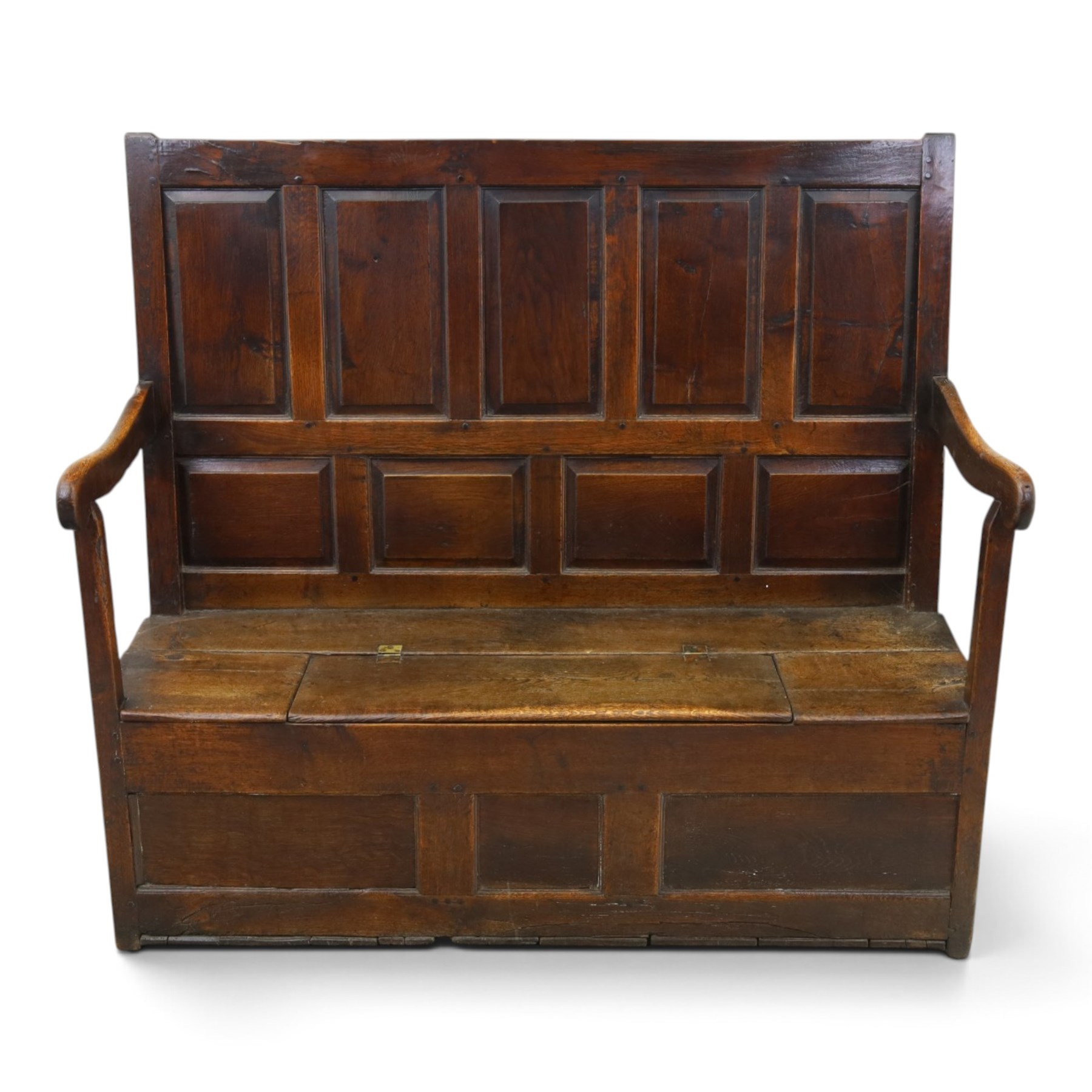 18th century oak high-back settle or hall bench, the panelled back and arm terminals over a hinged box seat, panelled front on short stile feet