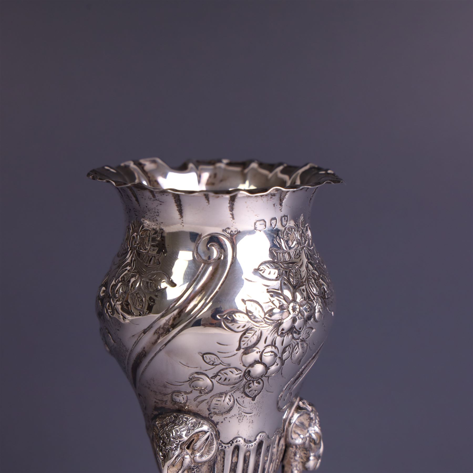 Late Victorian silver vase, of baluster form with fluted rim, the body with embossed floral decoration, upon three tall legs with ramshead mounts, hallmarked William Comyns & Sons, London 1890, H13.5cm