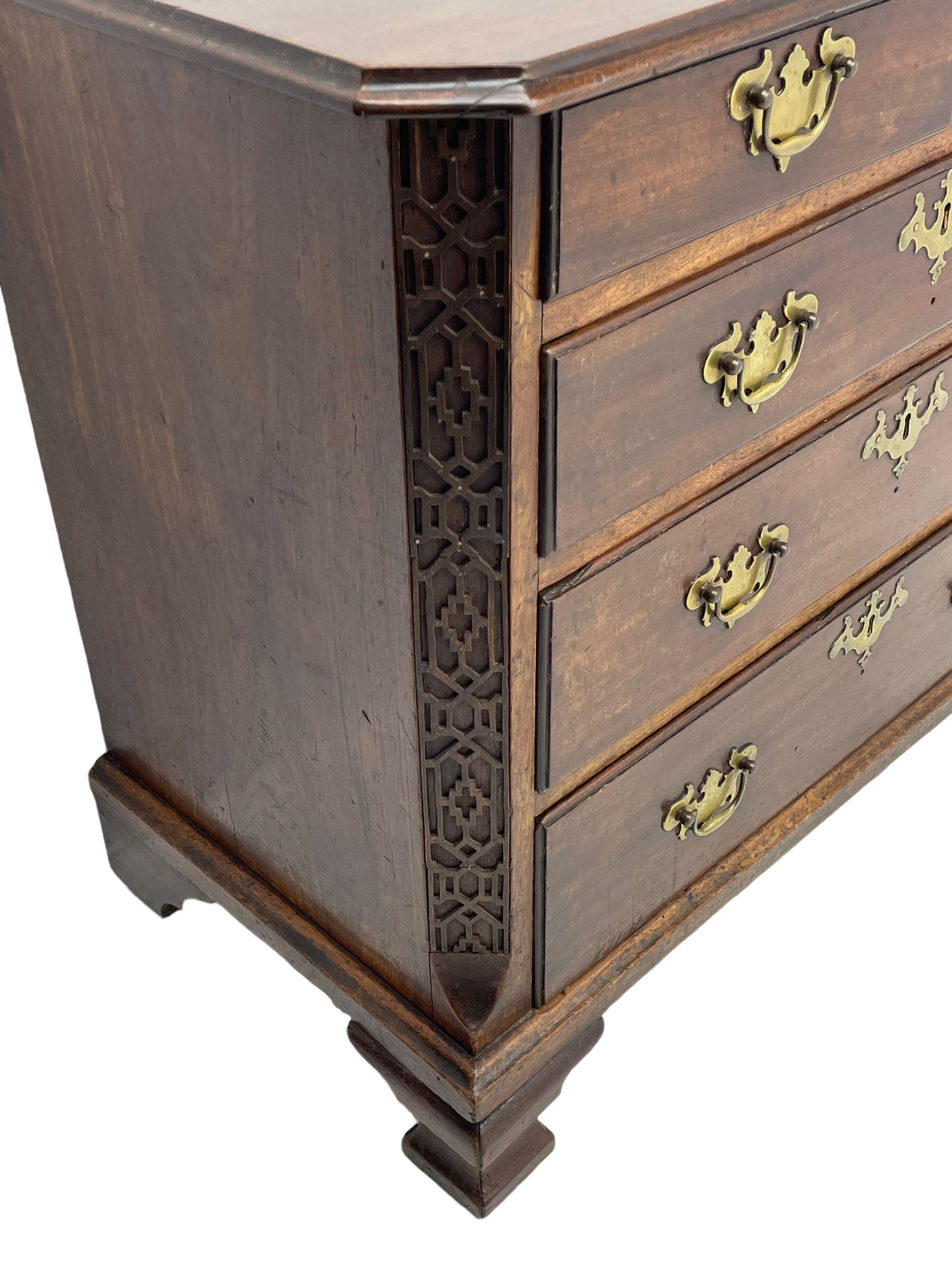 George III Chippendale design mahogany chest, moulded rectangular top with canted corners, wide canted uprights with blind fretwork decoration, two short and three long with moulded fronts, shaped brass handle plates, on ogee bracket feet 
