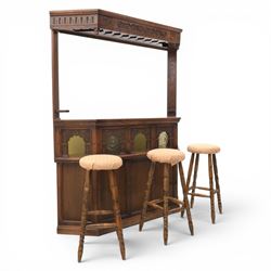 Old Charm - carved oak bar with three bar stools and associated Old Charm drinks cabinet, carved top with channels for glassware beneath, bar surface above glazed panels, shelves for glassware to the back, associated Old Charm drinks cabinet with fall front linenfold carving, above twin doors with shelved interior