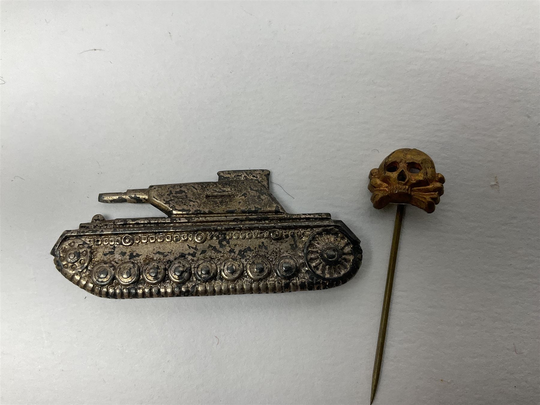 Collection of eleven German metal and cloth badges and uniform buttons including driver's badge, two 'SS' fabric skulls, private's shoulder tabs, Police cloth badge, tank destruction badge, medal bars and ribbon etc; most WW2 period