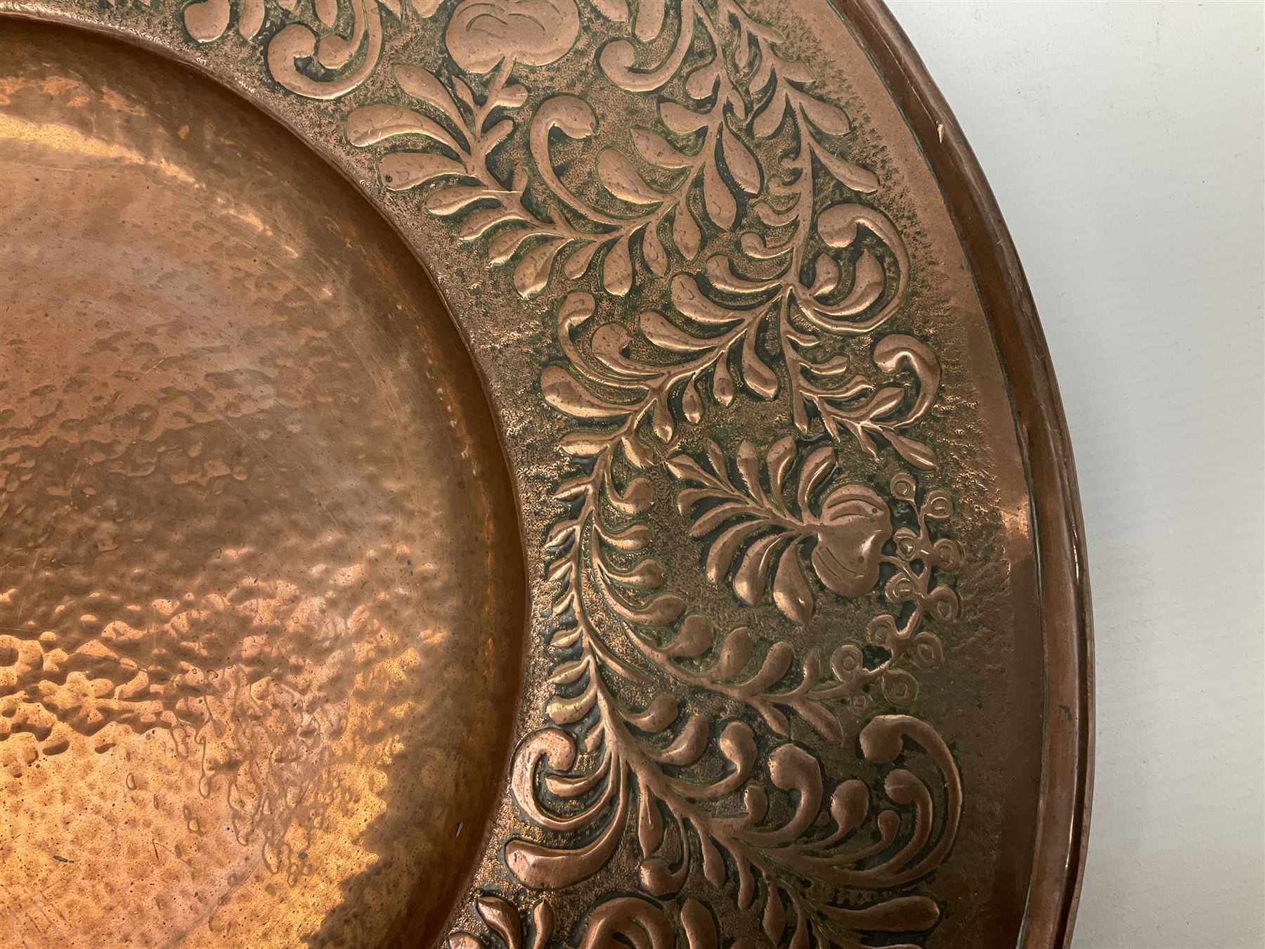 Arts and Crafts Keswick School of Industrial Arts copper charger, decorated with planished centre and repousse scrolling foliate tendrils to rim, D44cm