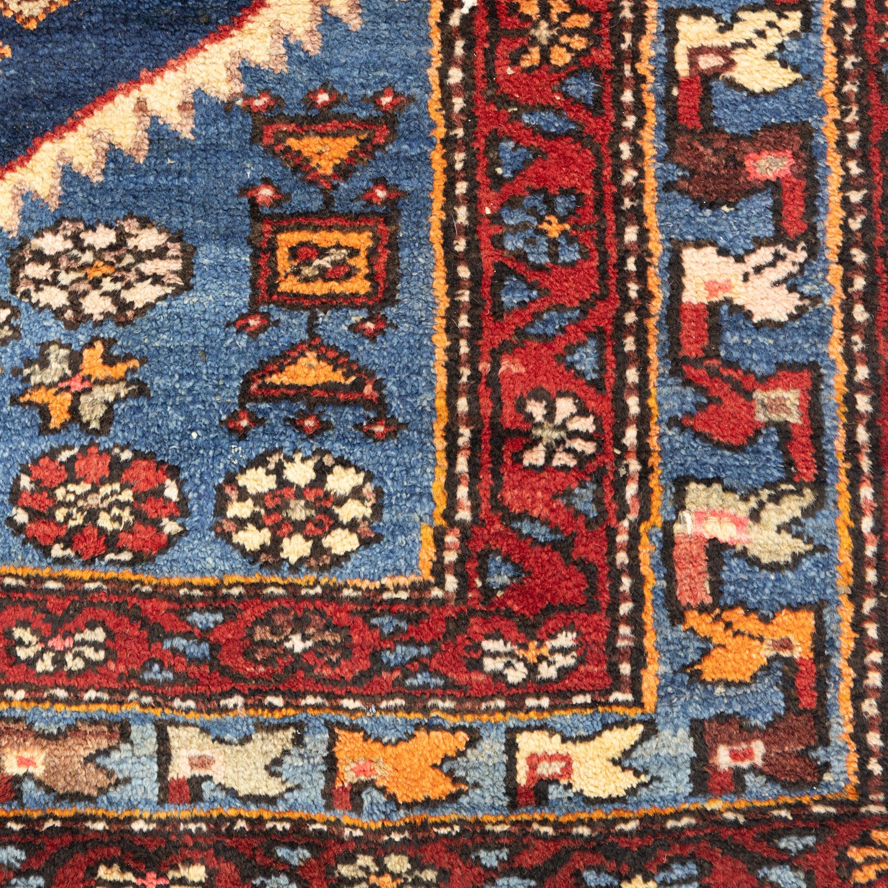 Persian Qashqai rug, wool on cotton foundation, triple stepped lozenge medallions with stylised motifs on a blue ground, within floral and geometric borders in rich red and cream
