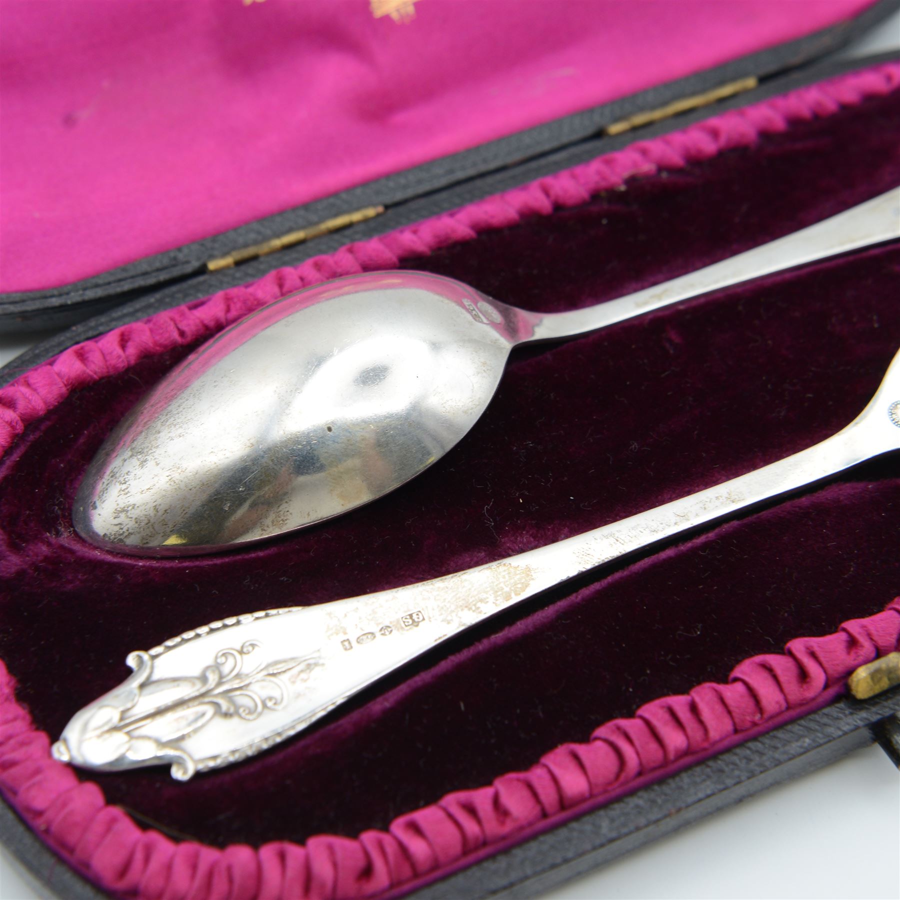1920s Danish silver spoon and fork set by Georg Jensen, stamped 925S Georg Jensen, with import marks for London 1926, contained within fitted tooled leather retailers case, together with two Georg Jensen silver-gilt year spoons, comprising 1975 example with enamel woodruff flower decoration, with personal inscription verso and a 1973 example with enamel marigold decoration, both boxed
