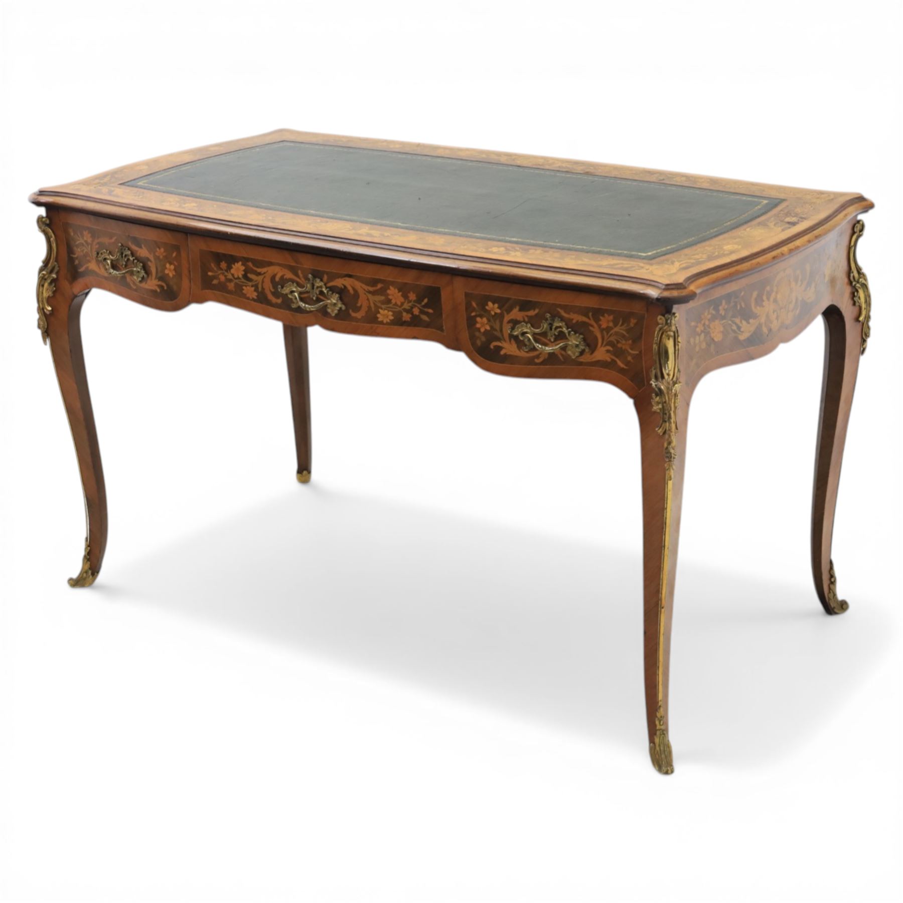 Late 19th century French kingwood and marquetry bureau plat, the serpentine rectangular top with green leather inset writing surface within crossbanded and foliate marquetry border, above a shaped frieze fitted with three drawers with floral marquetry panels and gilt metal handles, upon cabriole supports with applied gilt metal mounts and sabots