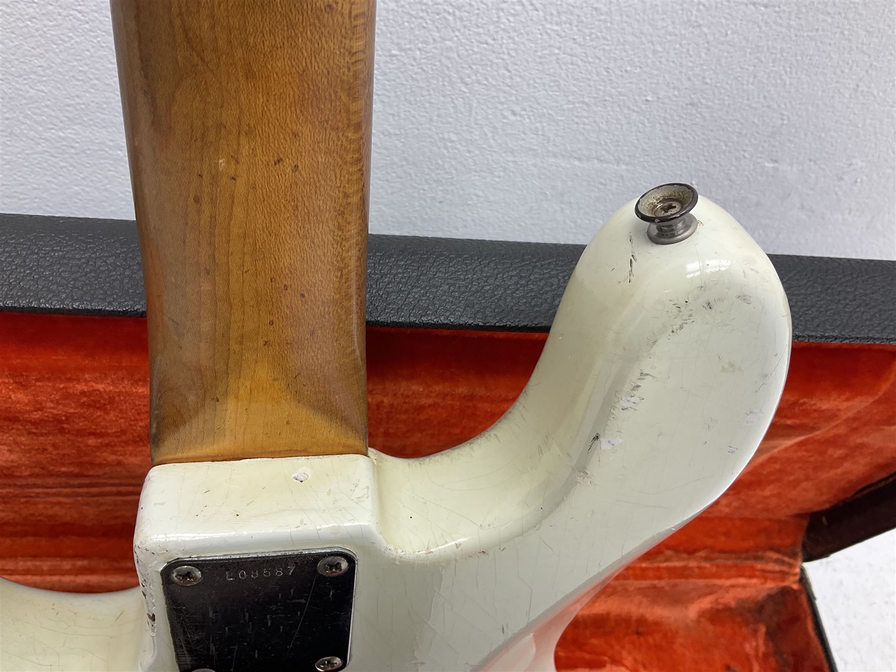 1963 Fender Jazz three-knob bass guitar; impressed with date code 7AUG63A on end of neck and serial no.L08587 on back plate; all original but re-finished in white in the 1970s; sold with photographs of the instrument in the 1960s with original finish and in the 1970s re-finished; L117.5cm; in original hard carrying case; Provenance: the professional guitar of Howard Livett from new to his death in 2005. Howard played in The Humperdincks, the backing group for Englebert Humperdinck, also played in the backing group for Max Bygraves and in the band Hedgehoppers Anonymous. The guitar is also sold with a manuscript letter of provenance from Howard's wife.