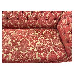 Late 20th century upholstered Chesterfield sofa, in red damask floral fabric, with deep buttoned back and arms, scrolled arms at equal height to back, on turned front supports