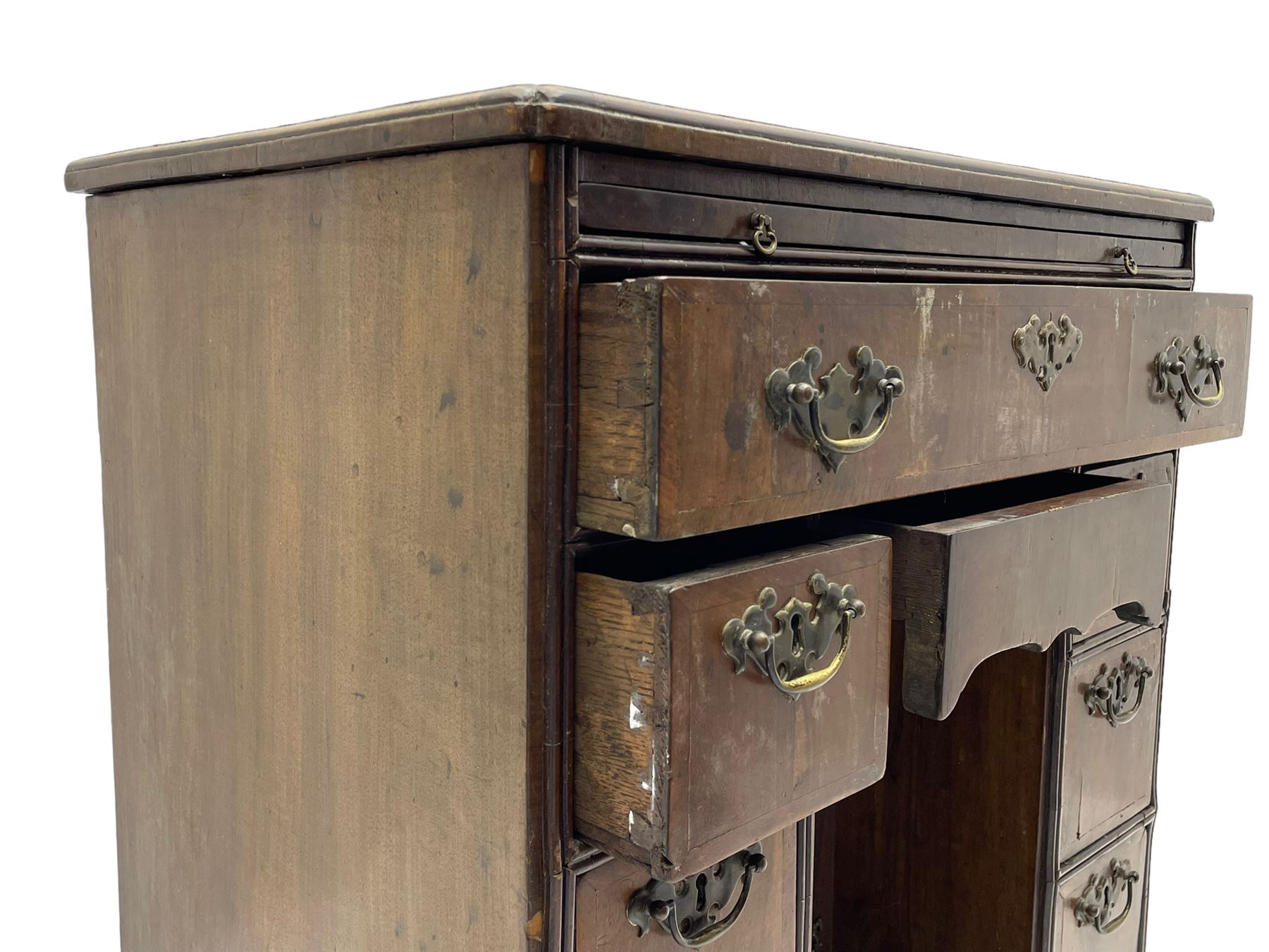 Georgian walnut kneehole desk, moulded rectangular top with book-matched veneers within crossbanding, fitted with slide over one long drawer, frieze drawer, six small drawers and recessed cupboard, raised on bracket feet