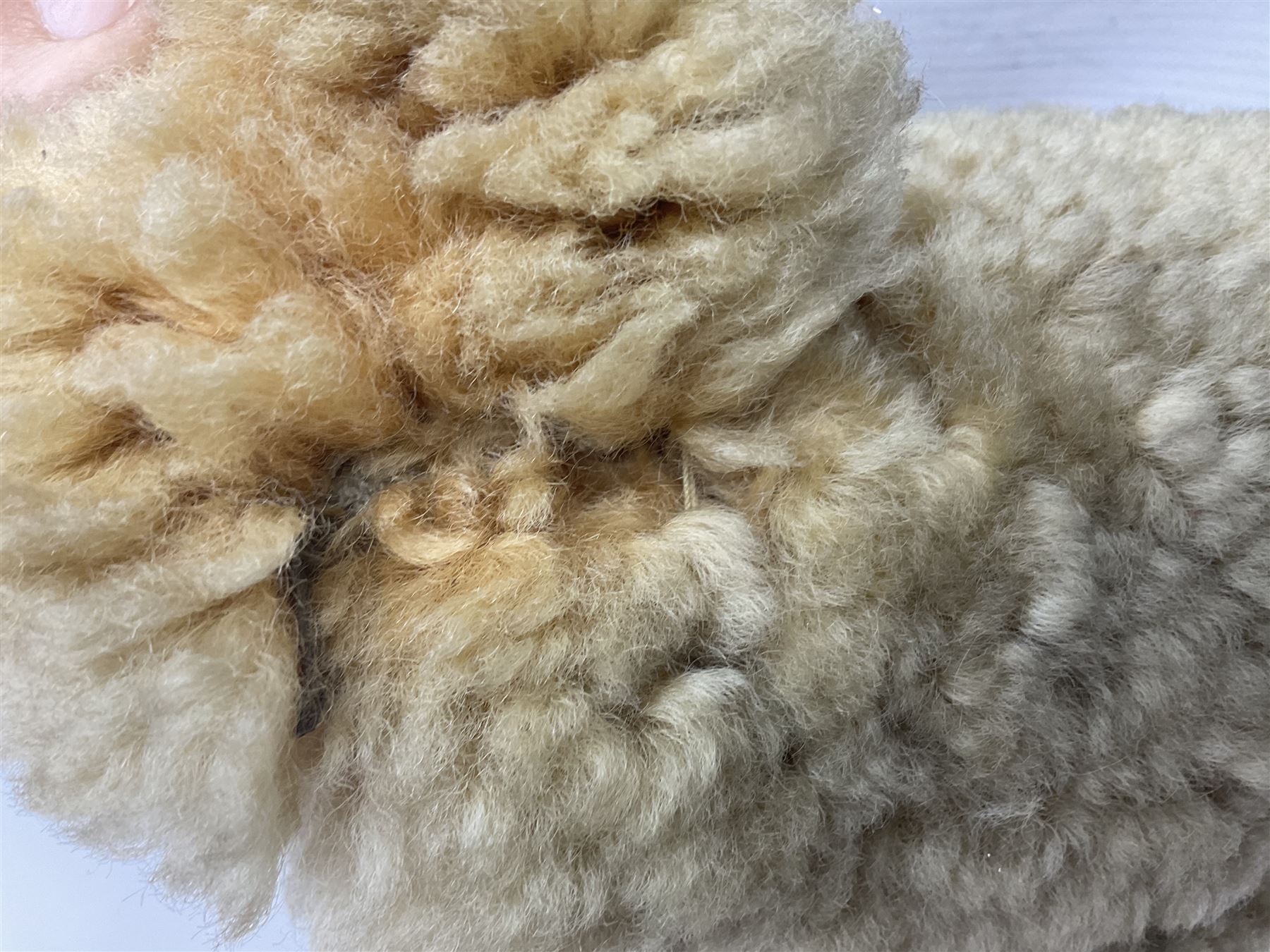 1950s sheepskin plush covered teddy bear with musical movement, the revolving head with applied eyes, leather nose and stitched mouth, jointed limbs with leather pads H50cm