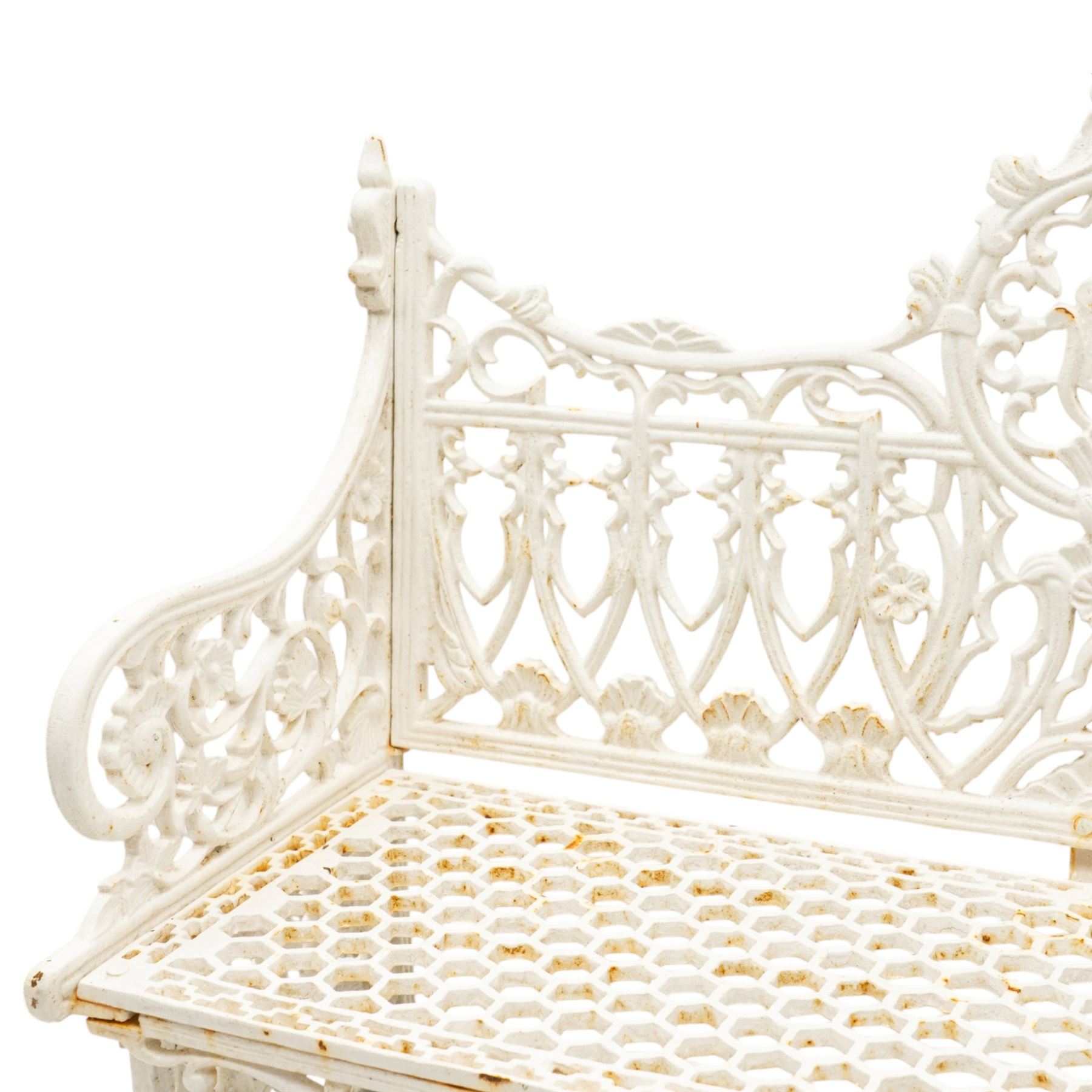 Victorian revival heavy cast iron garden bench, ornate back rest with scrolls, floral motifs and central crest, pierced lattice seat, curved arms and decorative legs, painted in antique white, in the Gothic Coalbrookdale style