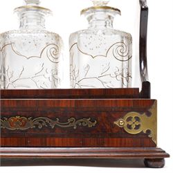 Amboyna three bottle tantalus, the cut glass spirit decanters decorated with raised naturalistic decoration heightened in gilt, with brass corner mounts and singular carrying handle, H32cm