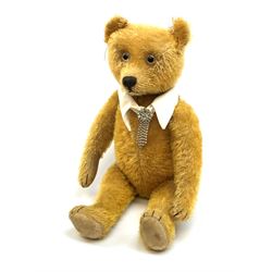 Schuco 'yes-no' teddy bear c1925 with wood wool filled short golden mohair body, linen pads with stitched claws and  tail-operated moving head with glass eyes and vertically stitched nose and mouth H18