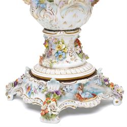 Pair of 19th century Potschappel porcelain two handled vases with covers and stands, painted with scenes of classical figures including Dionysus and Ariadne and with profusely applied flower heads on a scrolling field with gilt highlights H49cm (2)