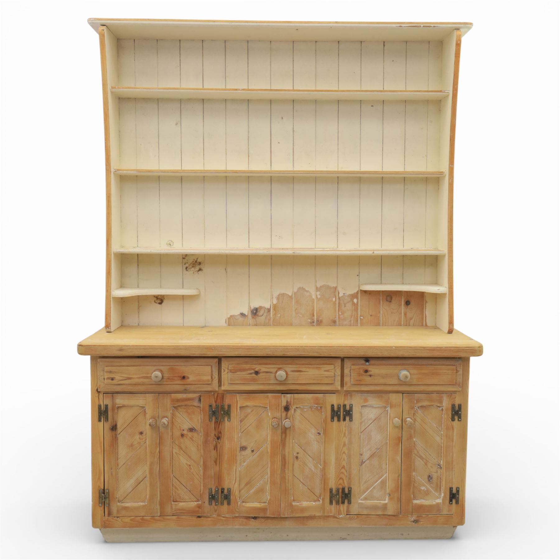 Late 20th century pine and white painted dresser, the upper section with three shelves and boarded back, upon a base with three drawers with knob handles and three panelled cupboard doors, on a raised sled base