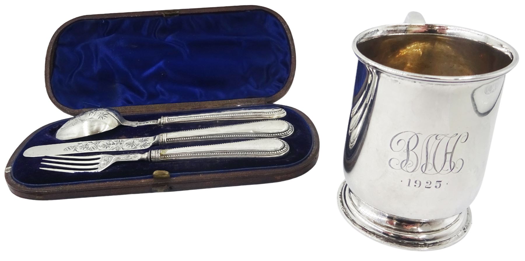 1920's silver christening mug, of plain form with engraved monogram and date to body and scroll handle, upon a circular stepped foot, hallmarked Walker & Hall, Birmingham 1925, H8.5cm, together with a Victorian silver three piece christening set, comprising knife, fork and spoon with beaded edge, hallmarked London, probably 1865, makers mark indistinct, contained within a fitted case with blue silk and velvet lined interior, approximate total silver weight 6.26 ozt (195 grams)