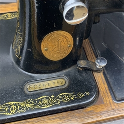 A vintage mid 20th Century cased Singer manual sewing machine, within faux crocodile carry case.