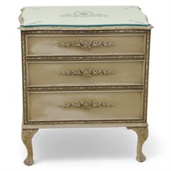 French design cream painted three drawer commode, shaped front with floral garland appliqués, fluted uprights and acanthus carved cabriole legs terminating in scroll feet