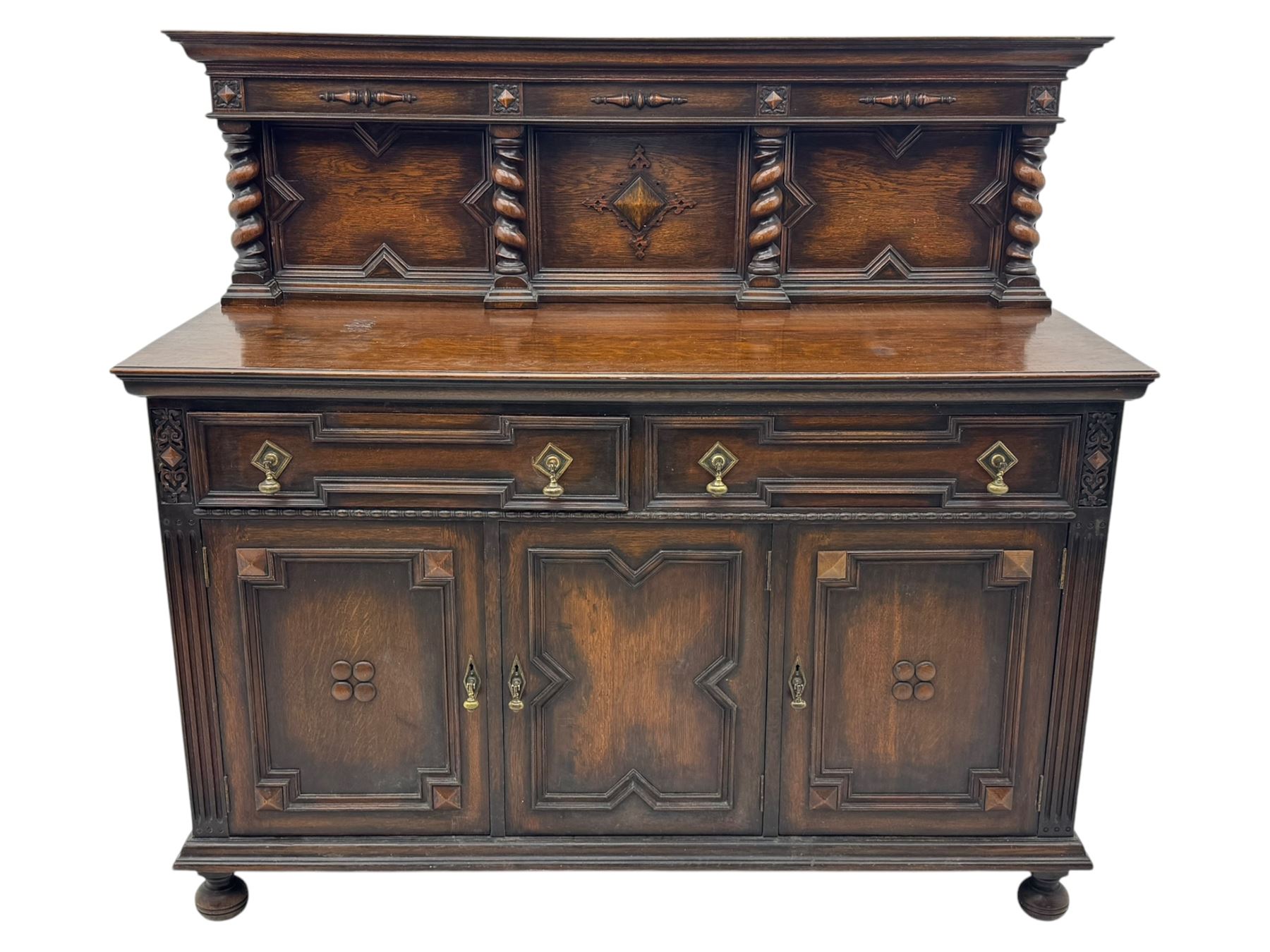 Jacobean-style oak dresser base with two frieze drawers above three cupboards with panelled and moulded decoration, fitted with drop handles, supported on bun feet, circa 1900