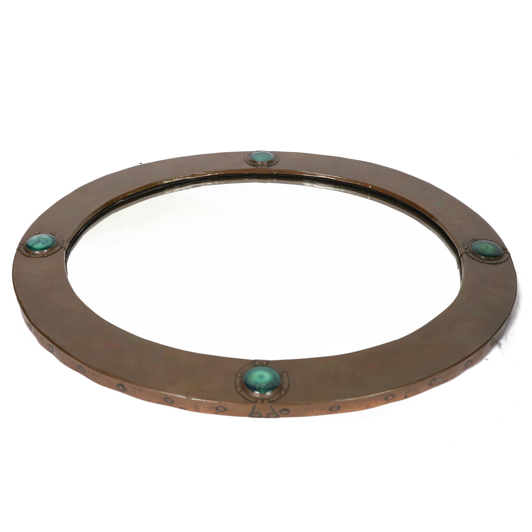 Liberty & Co, Arts and Crafts hammered copper framed oval wall mirror, mounted by four turquoise Ruskin cabochon roundels, with ivorine maker's label verso
