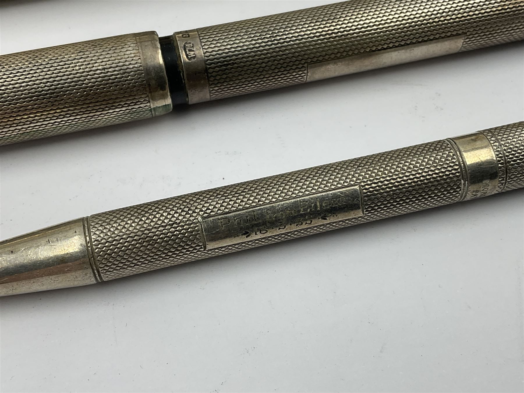 Three parker fountain pens, one example with 14ct gold plated cap and personal engraving, in Parker 51 box, together with a silver Sampson Mordan Everpoint propelling pencil with personal engraving and a silver cased fountain pen with 14ct gold nib and a souvenir bronze Dollfus-Mieg medallion, awarded to John G Sedorski, in fitted case 