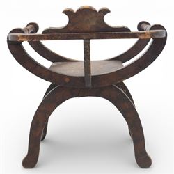 Late 19th century Savonarola style oak chair, X-frame construction with carved and shaped cresting rail, the curved arms with chip carved decoration, turned horizontal supports, solid dished seat with adzed surface, raised on shaped splayed feet