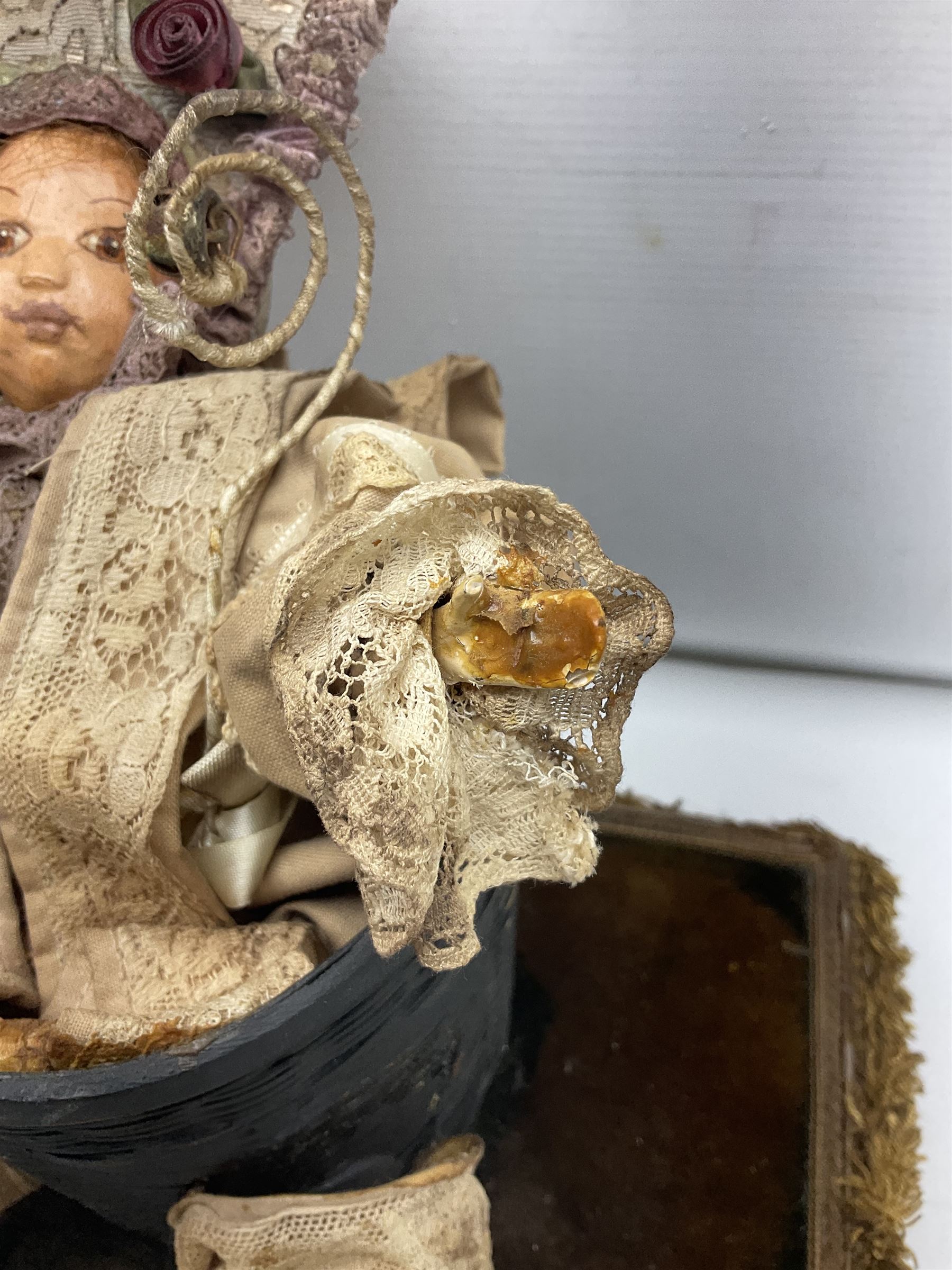 Modern reproduction automaton in the form of a baby doll in a basket clothed in Victorian style lace bloomers and frilled bonnet; clockwork action; on raised platform; with French paper label on base, 29cm wide,