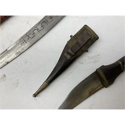 Near pair of African Moroccan Berber tribal Shula daggers each with engraved 39cm curving fullered steel blade, carved and inlaid horn grip and leather covered scabbard L57cm overall; kindjal style dagger with brass covered and jewelled grip and scabbard; another Eastern dagger with leather covered grip and scabbard; and a large Eastern knife with animal hide scabbard (5)