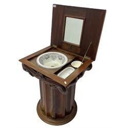 Victorian mahogany vanity unit in the form of a column, the scrolled top with hinged lid revealing mirror, wash bowl and toiletry dishes, on scalloped cylinder pedestal with single door, the interior fitted with shelf