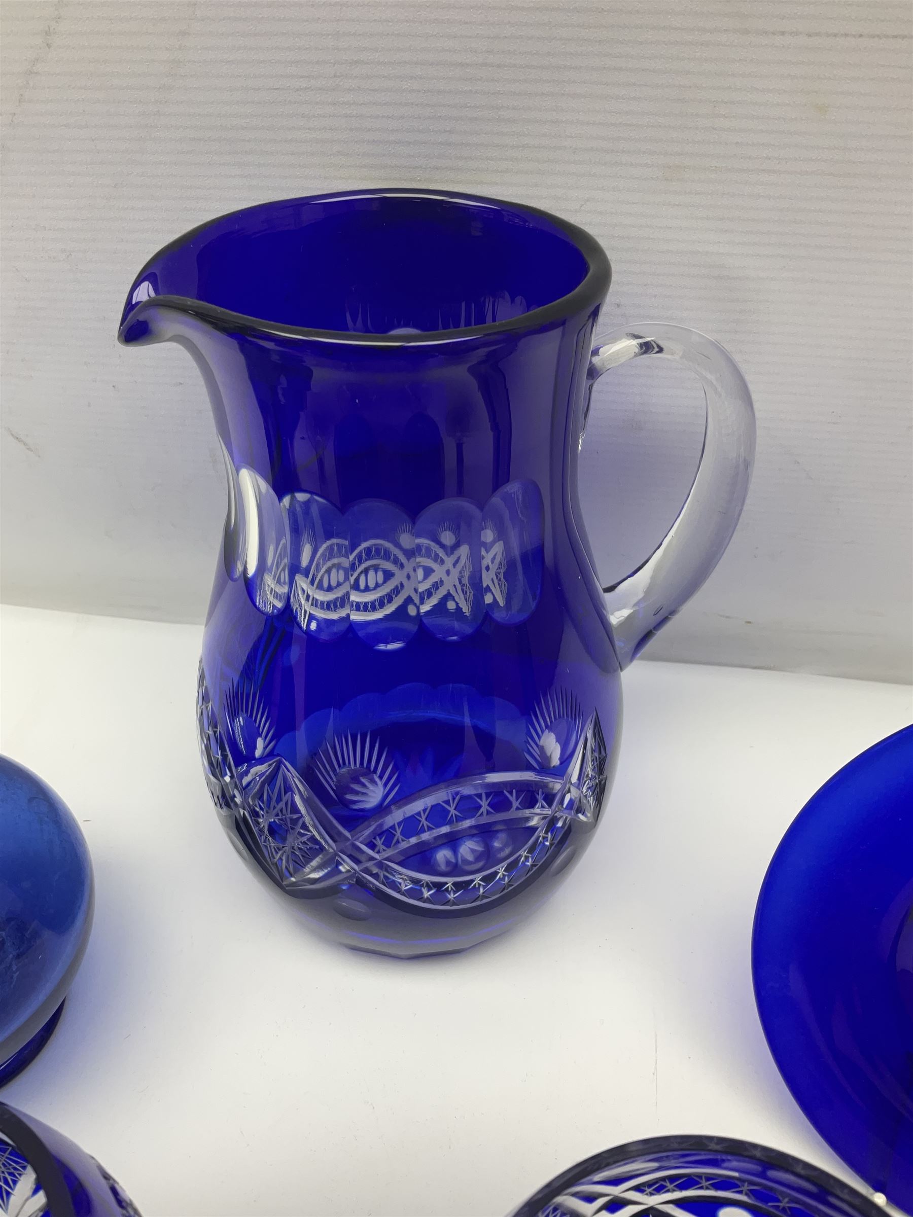 Bristol blue glass jug, together with blue claret jug, saucer, blue cut water jug, and seven matching glasses, water jug H22cm