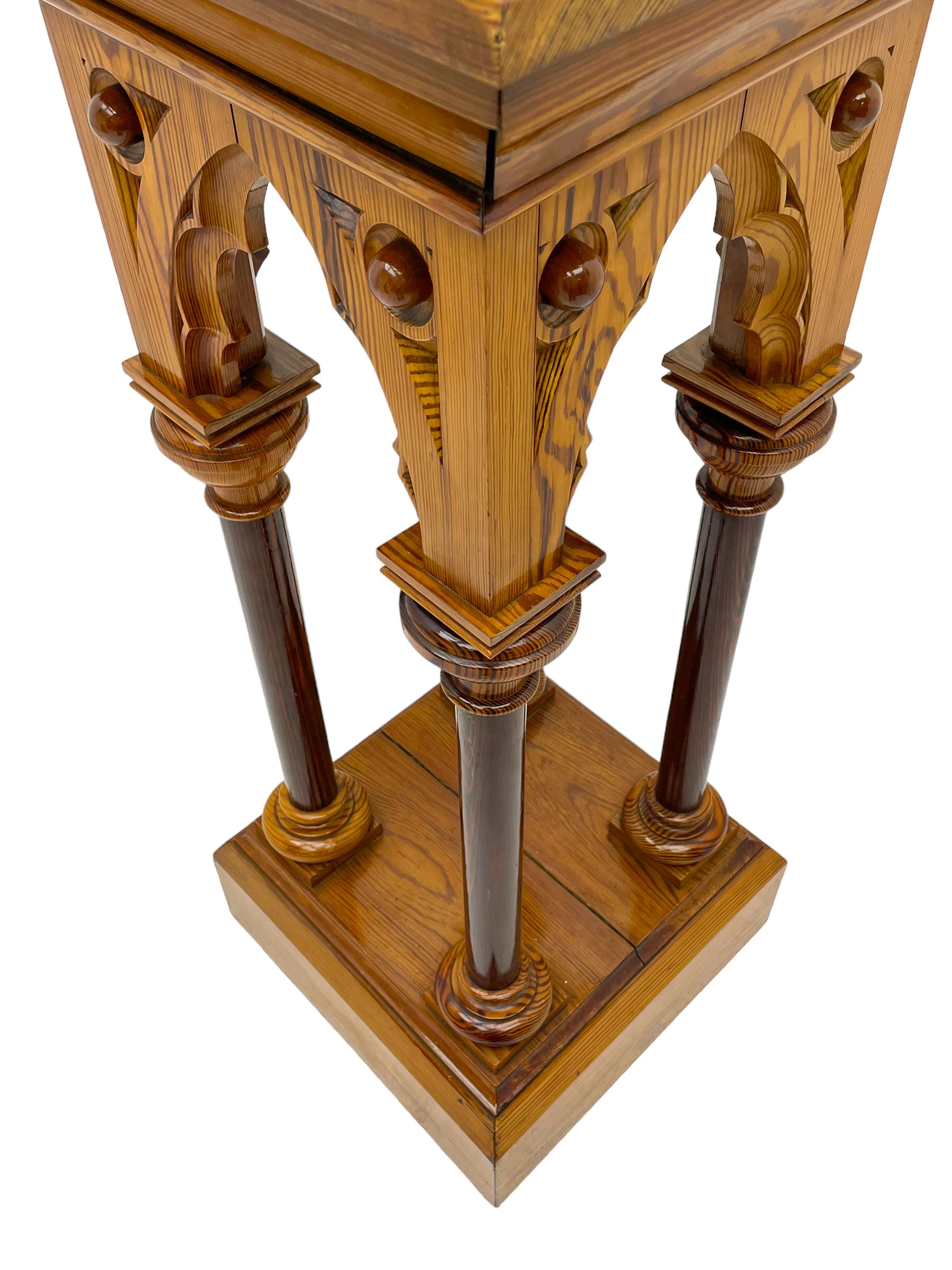 19th century pitch pine ecclesiastical pedestal stand, the square chamfered top over cusped Gothic pointed arches and four turned column supports, stepped and moulded plinth base