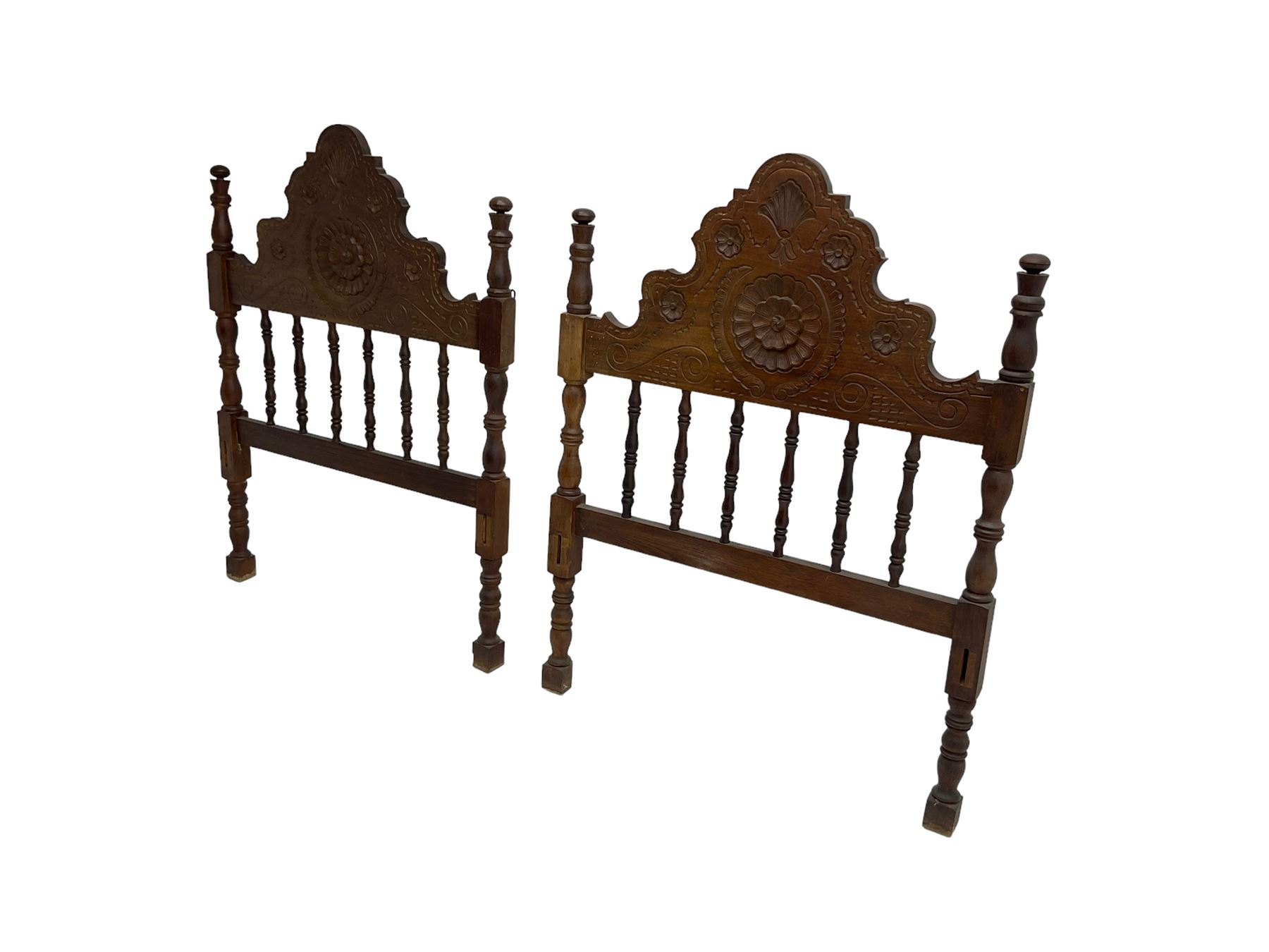 Pair Spanish stained beech single 3' bedsteads, spindle turned backs and carved with scrolling floral decoration 