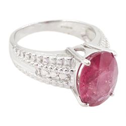 18ct white gold ruby and diamond ring, single oval cut ruby of approx 5.05 carat, with three round brilliant cut diamonds to each shoulder, Birmingham 2006