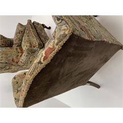 Matched pair early 20th century Queen Anne style wingback armchairs, walnut framed, sprung seats with seat cushions upholstered in needle work cover, shell carved cabriole front feet