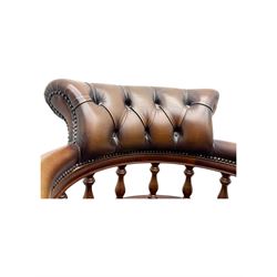 Mahogany framed swivel Captains desk chair, upholstered in brown buttoned leather, turned supports and swivel base on castors