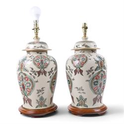 Pair of table lamps, decorated with foliate patterns upon a cream ground, H48cm