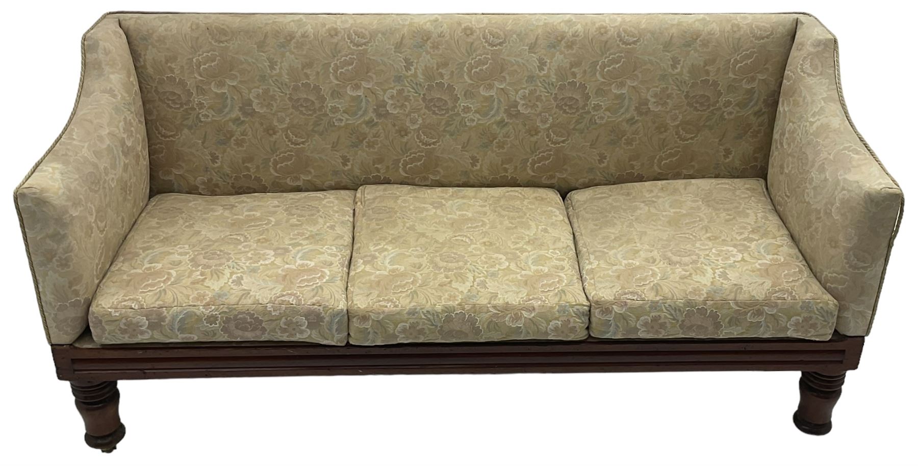 Victorian mahogany framed three-seat settee, upholstered in floral pattern fabric, on turned feet with brass and ceramic castors 