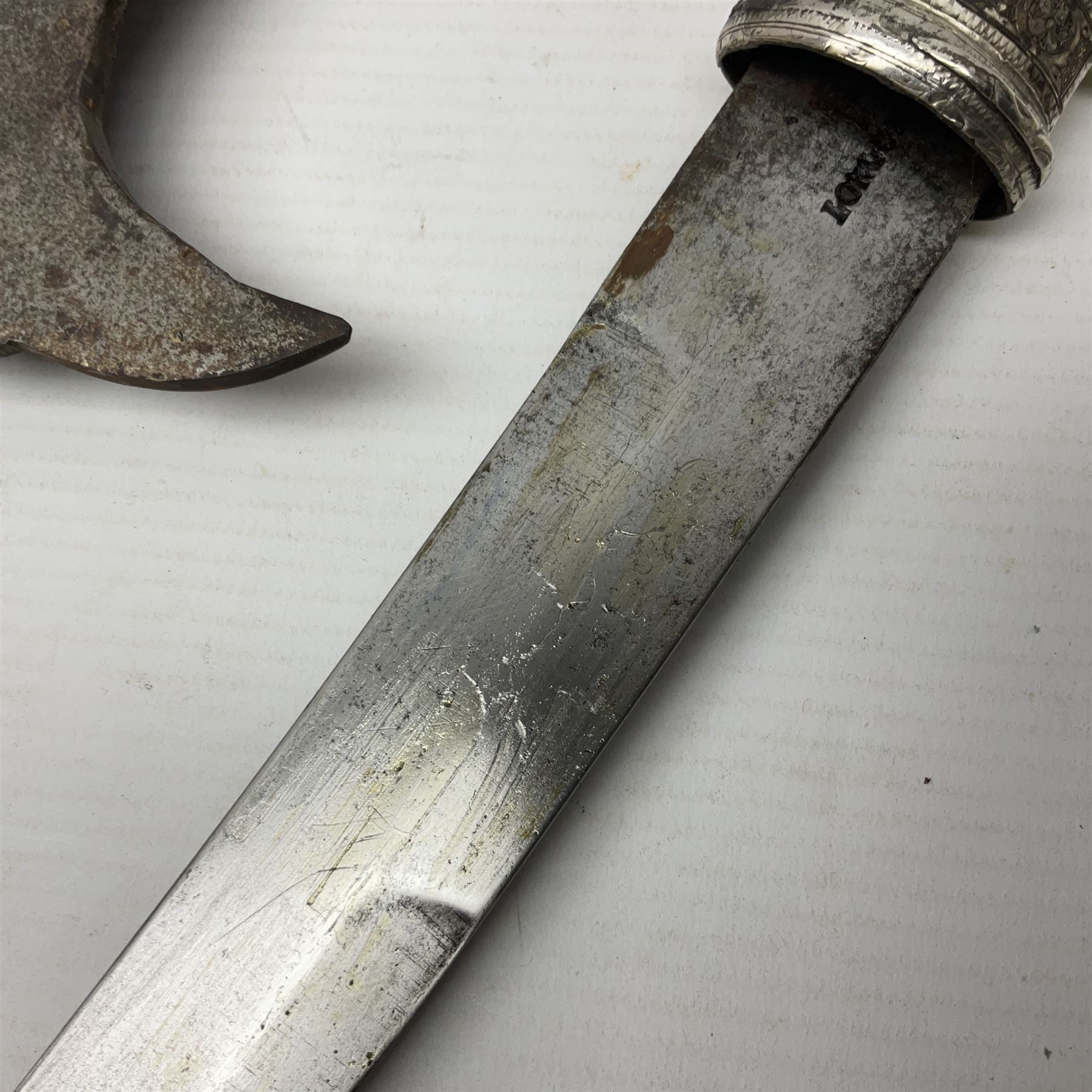 Moroccan jambiya dagger with 24.5cm plain curved blade stamped LONDON to the ricasso area, the hilt and scabbard overlaid with plain sheet brass to the back and ornate silver coloured metal to the front; waisted grip and arched pommel; two pyramid mounts to the scabbard L41cm overall; large billhook with curving blade and stacked leather washer grip; and a reproduction halberd blade (3)
