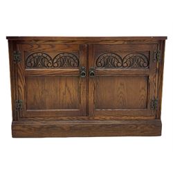 Mid to late 20th century oak cupboard, rectangular top over two doors carved with lunettes, on plinth base