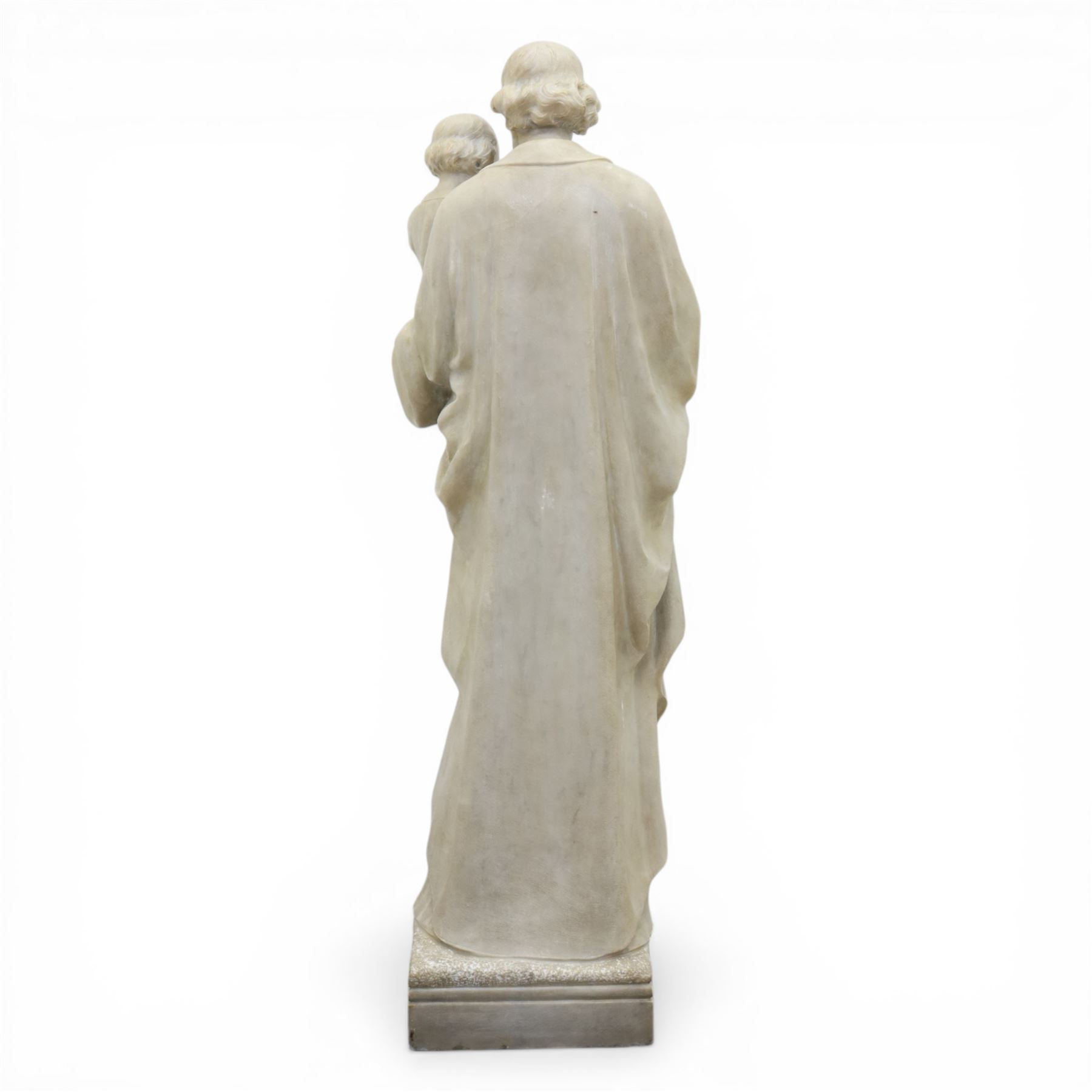 Carved stone and alabaster figure group of Saint Joseph and the Christ Child, modelled standing holding the infant, draped in flowing robes, raised on square plinth base